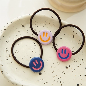 Three-piece set of high-elasticity hair ties with colorful smiley face charms on a tray