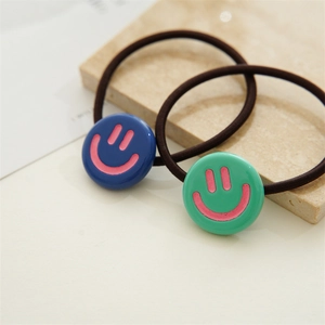 Detail of high-elasticity hair ties featuring cute blue and green resin smiley faces