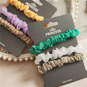 Detail of colorful fabric scrunchie set including floral and plaid patterns for ponytail