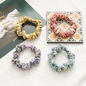 Lot de quatre chouchous en tissu à fleurs avec motifs marguerites en tons pastels