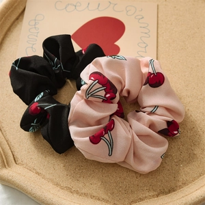 Detail of cherry print scrunchies in black and pink chiffon fabric with elastic band