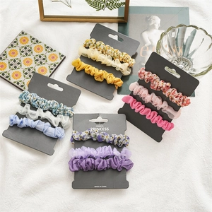 Lot de chouchous en mousseline florale aux couleurs pastel sur une carte cadeau chic