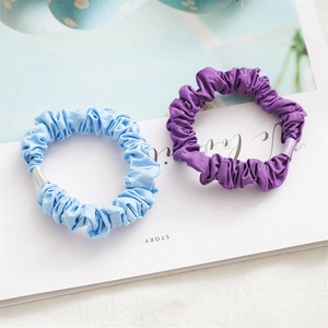 Detail of blue and purple fabric scrunchies showing soft pleated texture and quality sewing