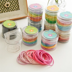 Dettaglio di elastici per capelli colorati ad alta elasticità in un barattolo cilindrico