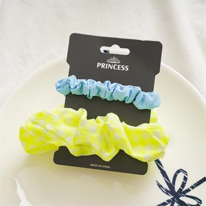 Close-up of light blue and yellow checkered scrunchies set on a black display card