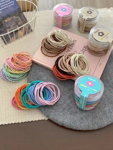 Dettaglio degli elastici per capelli colorati ad alta elasticità in un tubo trasparente