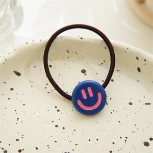 Close-up of a blue resin smiley face charm on a black high-elastic hair tie for women