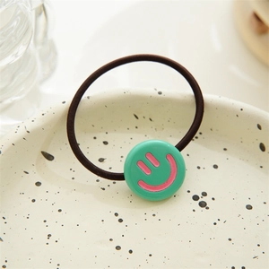 Detailed close-up of a high-elastic black hair tie featuring a bright green smiley face bead