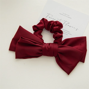 Detailed view of elegant burgundy satin double-layered bow hair scrunchie with silky shine