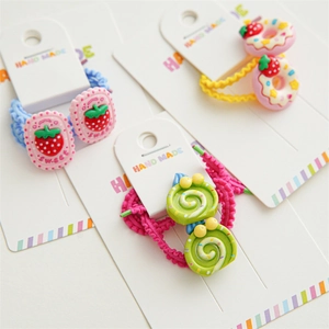 Set of three cute children hair ties with strawberry and donut resin charms on card
