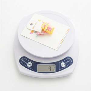 Detail view of a handmade children's hair tie set on a scale weighing 9.1 grams