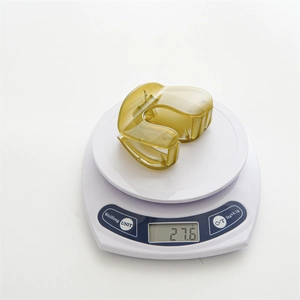 Amber translucent hair claw clip made of acrylic on a scale weighing 27.6g