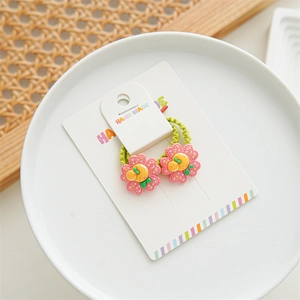Detail of pink flower hair ties for girls with yellow centers and green elastic bands