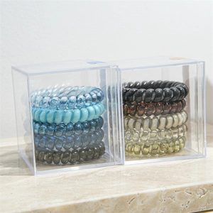 Detail view of elastic spiral hair ties in transparent storage boxes with various colors