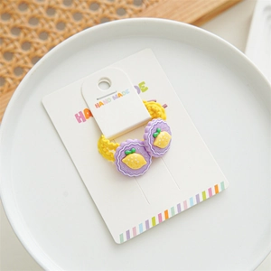 Detail of yellow elastic hair ties with purple lemon resin charms on a display card