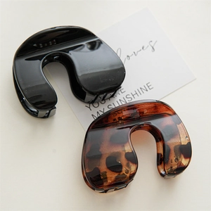Detail of minimalist U-shaped hair claws in black and classic tortoiseshell resin finish