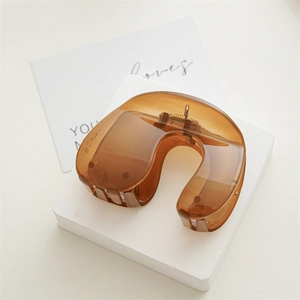 Detail of a large amber tortoise shell hair claw clip with a sleek U-shaped design