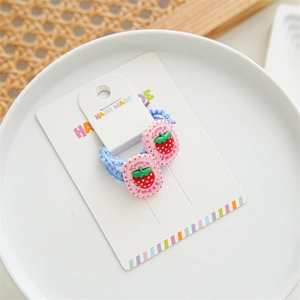 Close-up of sweet strawberry hair ties set with pink resin charms on a display card