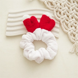 Détail du chouchou de Noël en peluche blanche avec des bois de renne rouges festifs