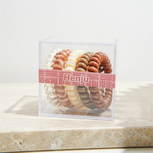 Macro shot of flexible spiral hair ties in earth-toned colors packed in a transparent box