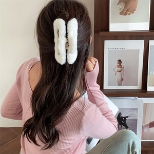 Vista posteriore di una modella che indossa una grande pinza per capelli in finta pelliccia