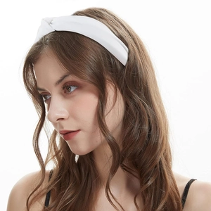 Close-up of a model wearing a white knotted headband in soft fabric for women