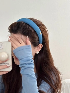 Serre-tête en éponge bleue rembourrée porté par un mannequin pour un effet volumineux