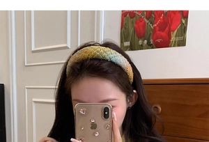 Close-up of a vintage tweed headband showing thick woven textures and multicolor knit details