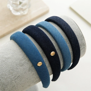 Détail de serre-têtes en denim rembourré en cinq nuances de bleu avec accents métalliques dorés