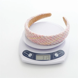 Pink tweed padded headband for women weighing 31.9g on a digital scale for lightweight comfort
