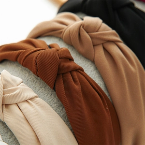 Macro shot of knotted headbands in beige, red, brown and black with twill texture fabric