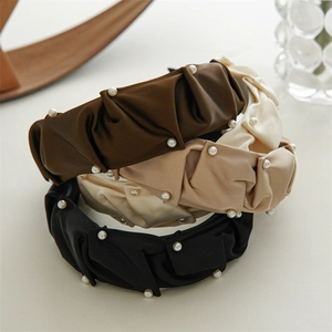 Detail of ruched satin headbands with small white pearls in brown, khaki and black