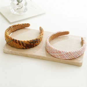 Close-up of woven tweed headbands in brown and pink colors on stone display