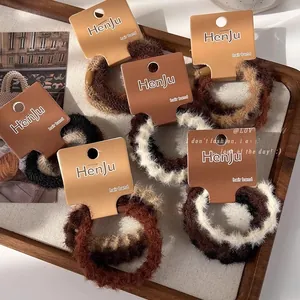 Gros plan d'élastiques à cheveux en peluche aux tons terreux sur un plateau en bois