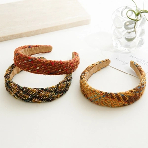 Detail view of tweed headbands in red, green, and orange showing woven textures