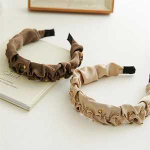 Coffee brown pleated satin headbands with pearls and rhinestones on desk setup