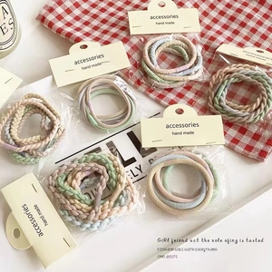 Détail de chouchous élastiques aux textures tissées dans des couleurs pastel macaron