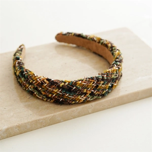 Detailed macro view of woven multi-color tweed fabric on a wide retro headband