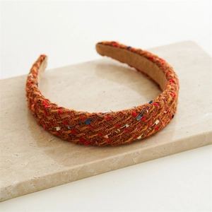 Detail of tweed headband showing colorful woven threads on marble surface