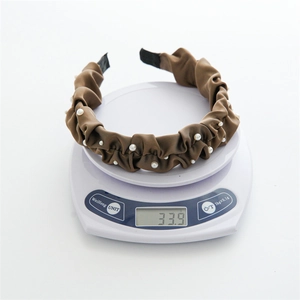Brown satin pleated headband with pearls on a digital scale weighing 33.9 grams