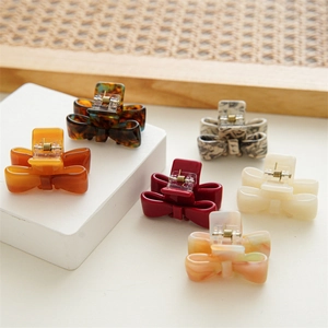 Detailed set of acetate bow hair claws in tortoiseshell, amber, and marble patterns