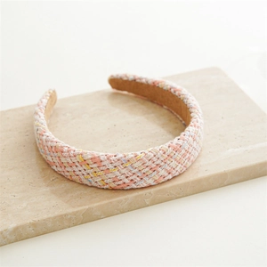 Detailed texture of tweed braided headband in pastel pink, yellow and blue colors