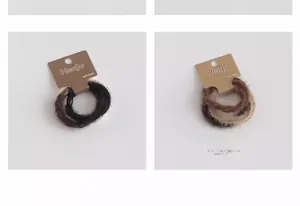 Lot de trois chouchous en peluche couleurs marron, noir et beige sur support carton