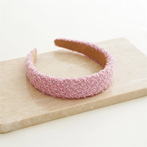 Detail of pink and white tweed headband showing woven fabric texture and non-slip lining