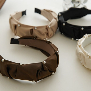 Detail of pleated pearl headbands in black, beige, and khaki with elegant ruching