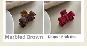 Close-up of tortoiseshell and magenta bow hair claws in acetate with metal springs