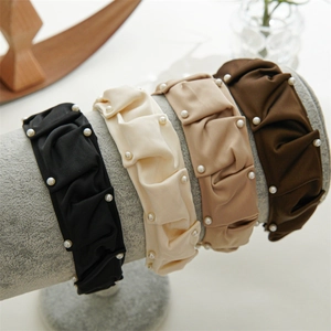 Close-up of four pleated satin headbands with white pearls in earth tone colors