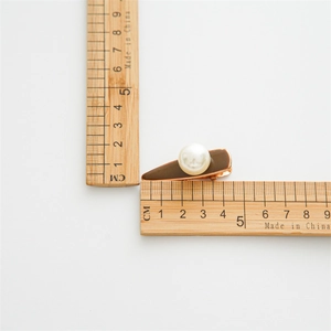 Detail view of a 4.5cm elegant pearl hair clip on a ruler for precise size measurement