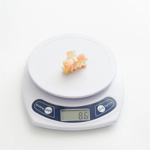 Small acetate marble bow hair claw clip for women weighing 8.6g on a digital scale