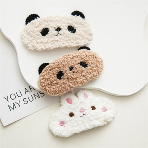 Close-up of three plush animal hair clips with cute panda and rabbit embroidery designs